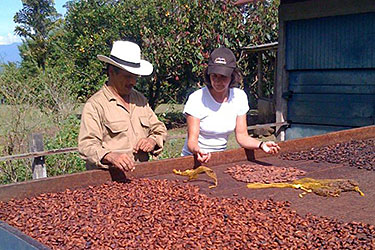 Gail and a cacao farmer drying beans