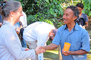 Gail shakes hands with a cacao farmer